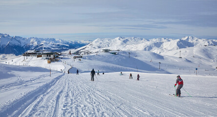 Fototapeta na wymiar Schönes Winterpanorama im Skigebiet Wildkogel bei Bramberg in Österreich, mit Skifahrer an der Piste.