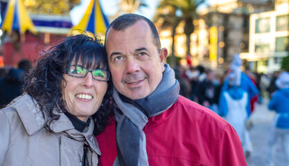 Happy caucasian couple attending Carnival Parade in Viareggio