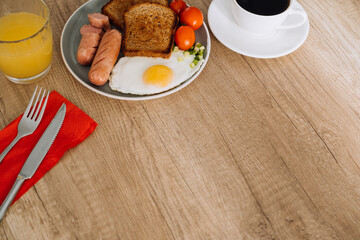 English breakfast with black coffee and orange juice on the wooden table with copy space