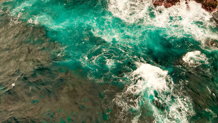 Turbulent waters near a rocky shoreline, amazing aerial view from drone