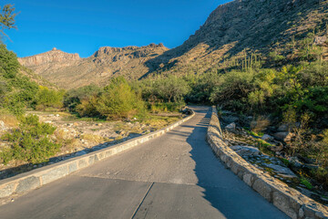 Paved hiking trail in Sabino Canyon along Catalina mountains on a sunny day. Scenic landscape of an outdoor recreation area with picturesque nature scenery.