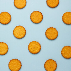 Pattern biscuits of round shape on blue background, flat lay