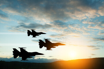 Air Force Day. Aircraft silhouettes on background of sunset. Combat flight of interceptors on a...