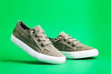 Walking shoes - sneakers. Modern fashion shoes on a green background close-up.