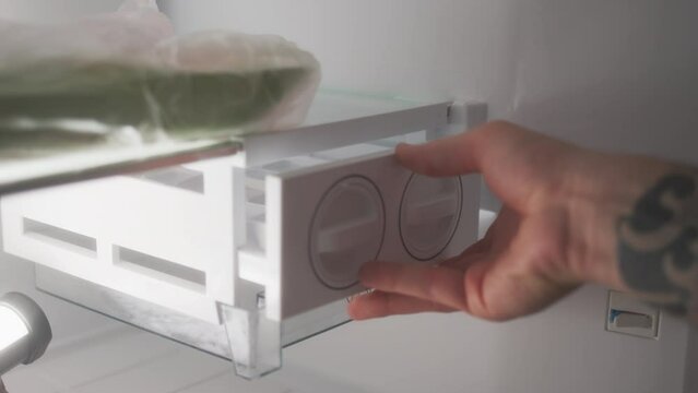 Close Up View Of Ice Container Being Inserted Into Place In Refrigerator In Ice Cube Compartment. Freezing Water For Making Cocktails At Home.