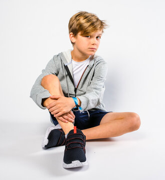 Blond little boy sitting on floor looking at camera