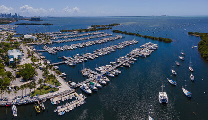Aerial view of boats in their slips againts scenic blue ocean in Miami Florida. Dinner Key Marina and Coconut Grove Sailing Club against beautiful nature scenery on a sunny day.