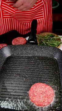 Chef is frying beef meat cutlets for burger.