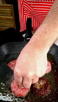 Chef is frying beef meat cutlets for burger.