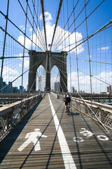 Rear view of cyclist riding on New York's Brooklyn Bridge.