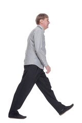 confident mature man in a white shirt striding forward.