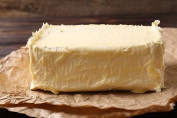 Piece of tasty homemade butter on parchment, closeup view