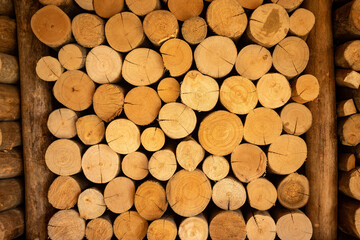 Background of stacked round brown logs.
