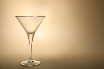 Elegant empty martini glass on beige background. Space for text