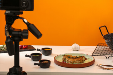 Professional camera on tripod and composition with delicious meat medallion in studio. Food photography