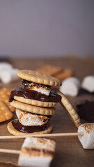 marshmallows, chocolate and cookies for making smore on brown background. view from above. copy space