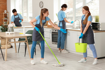 Young janitors cleaning in kitchen