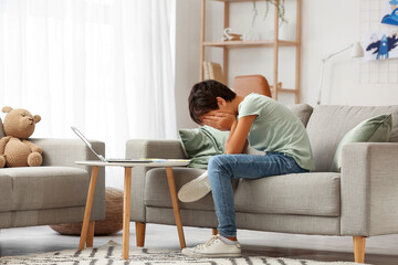 Upset little boy video chatting with psychologist at home