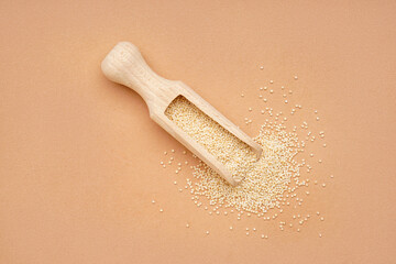 Wooden scoop with amaranth seeds on color background