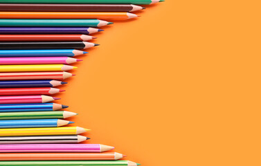 Set of colorful pencils on orange background