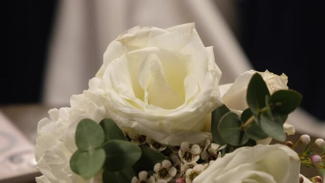 white rose flower bridal bouquet, wedding dress in background, bride waiting