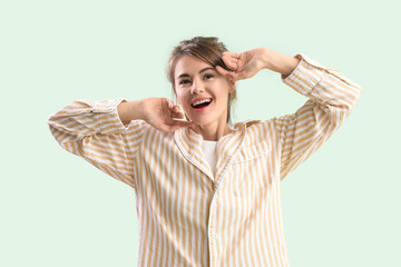 Awaken young woman stretching on green background