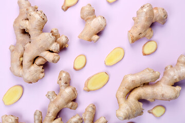 Ginger roots and slices on pink background, closeup