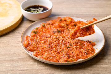 Kimchi pancake (Kimchi jeon or kimchi buchimgae) on plate eating with soy dipping sauce, Korean food