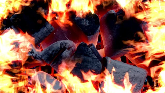 薪をくべ炭に火をつけ燃焼させるイメージ　周囲に炎