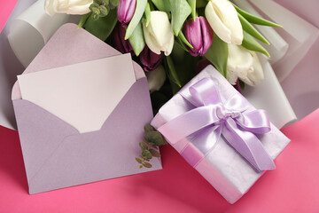 Envelope with blank card, gift box and bouquet of beautiful tulip flowers on pink background. Hello spring