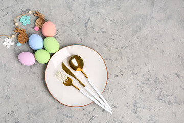 Table serving with Easter eggs on grey grunge background