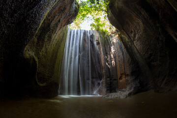 Fototapeta na wymiar Tukad Cepung - the waterfall flowing into a cave. Amazing nature of Bali, Indonesia.