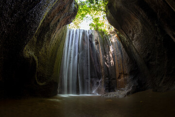 Tukad Cepung - the waterfall flowing into a cave. Amazing nature of Bali, Indonesia.