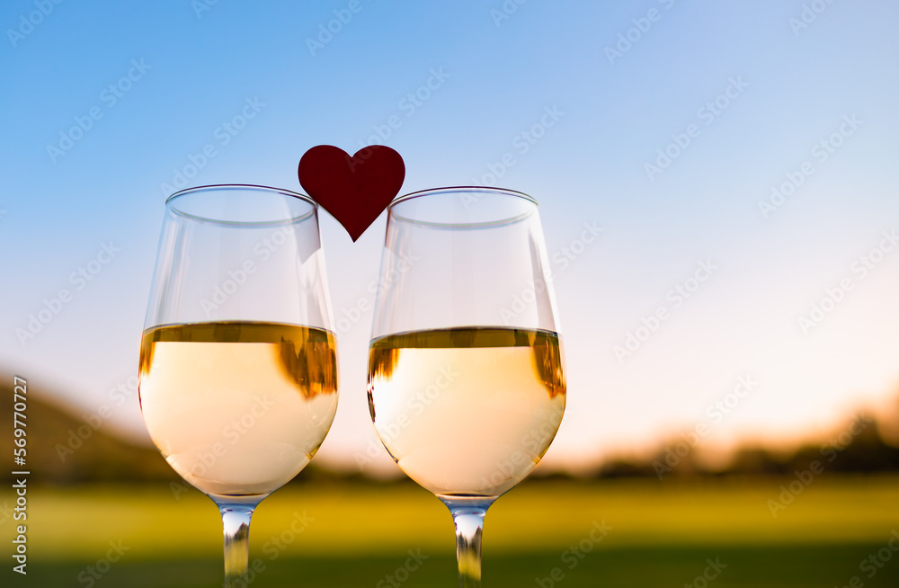 Sticker two glasses of wine and heart. romantic dinner date at sunset.