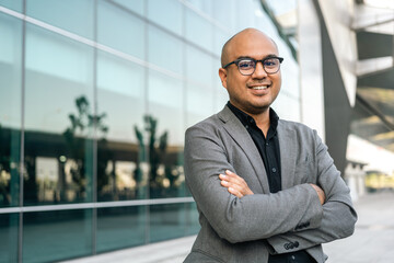 Senior manager business man in suit standing at the buildings downtown. Confident man arms crossed looking towards their goals for success. Executive business man