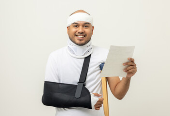 Asian man broken arm and leg holding bill payment. Man put on plaster cast splint with walking...