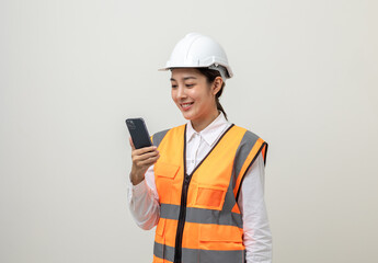 Asian engineer worker woman or architect with white safety helmet standing on isolated white background. Mechanic service factory Professional job occupation in uniform working with smartphone