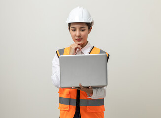 Asian engineer worker woman or architect with white safety helmet standing on isolated white background. Mechanic service factory Professional job occupation in uniform working with laptop computer