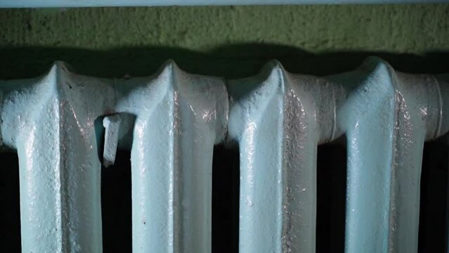 Cast iron sectional blue heating radiator close-up, smooth parallax. Outdated inefficient home heating system in winter