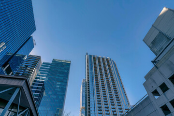 Looking up at modern residential buildings exterior towering against blue sky. Austin Texas skyline viewed from the street with facade of apartments, condominiums and offices.