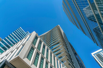 Glass facade of modern commercial buildings in downtown Austin Texas. Exterior of skyscrapers viewed from the ground against blue sky on a sunny day.