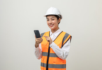 Asian engineer worker woman or architect with white safety helmet standing on isolated white background. Mechanic service factory Professional job occupation in uniform working with smartphone