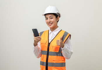 Asian engineer worker woman or architect with white safety helmet standing on isolated white background. Mechanic service factory Professional job occupation in uniform working with smartphone