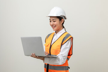 Asian engineer worker woman or architect with white safety helmet standing on isolated white background. Mechanic service factory Professional job occupation in uniform working with laptop computer