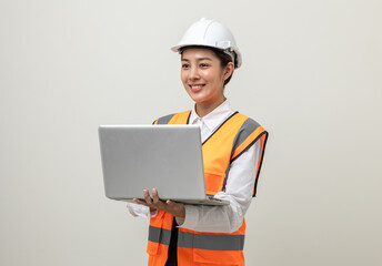 Asian engineer worker woman or architect with white safety helmet standing on isolated white background. Mechanic service factory Professional job occupation in uniform working with laptop computer