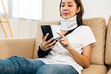Obraz premium Woman recovery from accident fracture broken bone injury with leg splints in cast neck splints collar arm splints sling support arm using smartphone. Social security and health insurance concept.