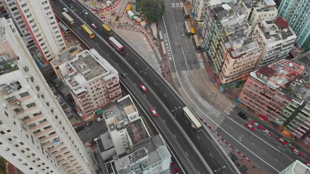 Kowloon traffic in Hong Kong. Aerial view of cars and trucks below. Drone above busy downtown streets in Asia, China. Popular travel destination.