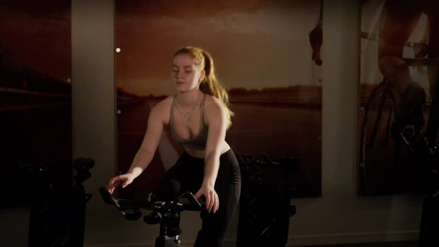 Young Woman Cycling On Exercise Bike In Gym
