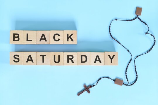 Black Saturday holy week concept. Wooden blocks typography with rosary flat lay in blue background.