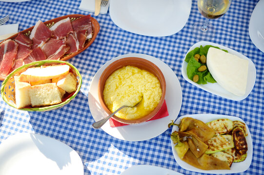 Traditional rustic treat in Montenegro. Prshut, vegetables, wine. Kachemak is a corn porridge mixed with crushed potatoes and kaymak, sheep cheese